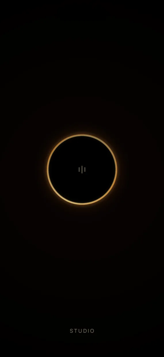 The resting screen — a dark disc ringed with amber light, three small strokes at its centre.